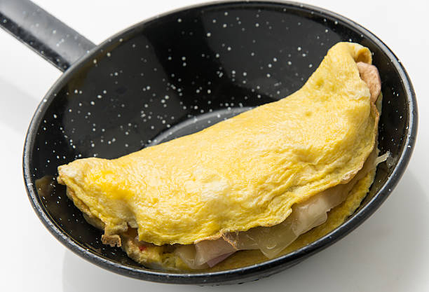 istock Cooked yellow omelet in black with white speckle frying pan. 175442630