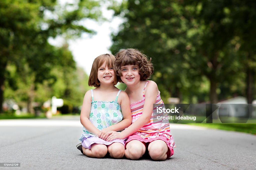 Duas irmãs feliz sorrindo e abraçando, em ambiente ao ar livre - Foto de stock de 6-7 Anos royalty-free