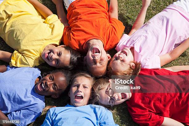 Foto de Meninas Deitada Em Um Círculo Olhando Para Cima e mais fotos de stock de Colônia de Férias - Colônia de Férias, Criança, Rindo
