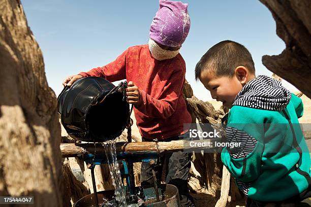 Mother And Son Working In The Extraction Of Water Stock Photo - Download Image Now - Child, Protective Face Mask, Removing