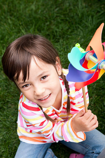 istock Young girl playing with a pinwheel 175444345