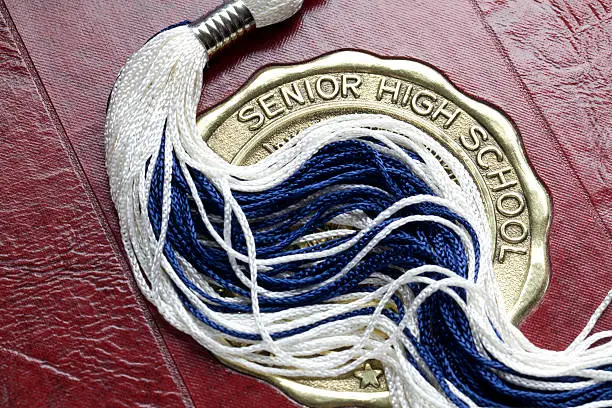 Mortar board tassel on high school year book.