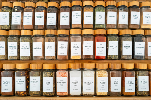 Large collection of glass spice containers in a drawer.