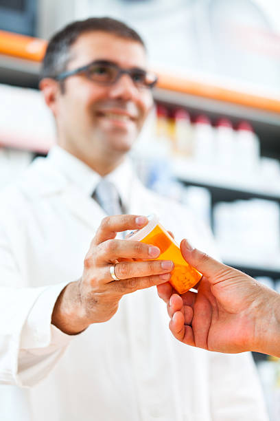 istock Pharmacist giving pill bottle to customer at the pharmacy 175445944