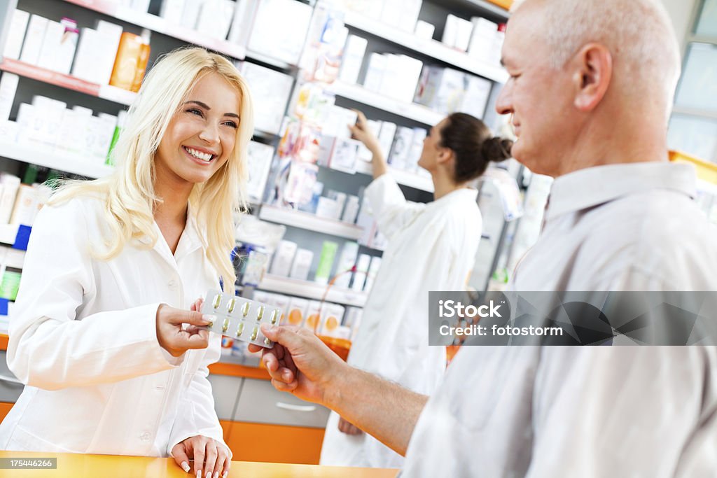 Farmacêutico dando Pílulas para um cliente - Foto de stock de Cabelo Louro royalty-free