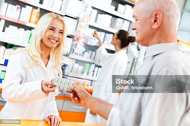 Foto de Farmacêutico Dando Pílulas Para Um Cliente e mais fotos de stock de Cabelo Louro - Cabelo Louro, Farmacêutico, Adulto