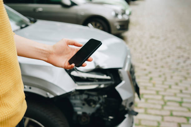 istock Man using smartphone standing next to the crashed car after the accident 1754465462