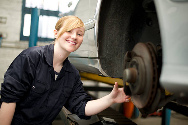 jovem mulher a trabalhar na garagem - trainee working car mechanic imagens e fotografias de stock