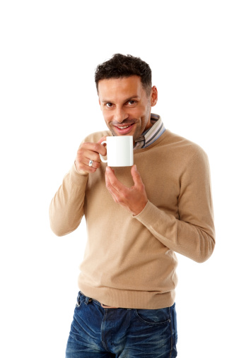 Portrait of relaxed young guy drinking cup of coffee against white background