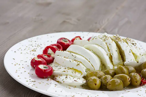 "Italian starter with buffalo mozzarella, olives and stuffed peppers"