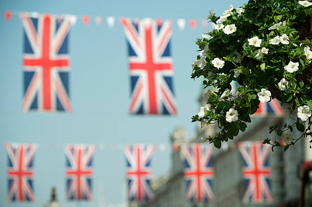 belle rue londonienne avec plantes et drapeau union jack - fête de rue photos et images de collection