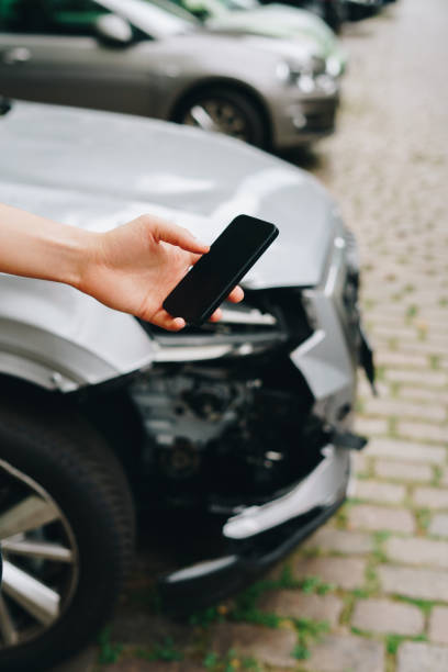 istock Man using smartphone standing next to the crashed car after the accident 1754476222