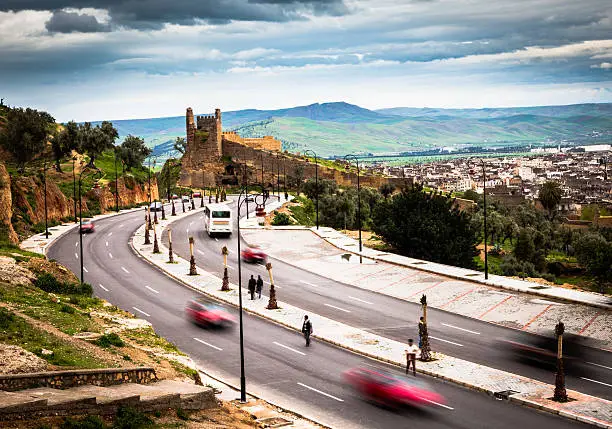 "View of street just outside the city wall of Fes ( Fez ), one of the imperial city in Morocco.Blur motion of the cars running.View from Borj Nord: on the right the old medina of Fes ( Fes el bali ) UNESCO world heritage site. On the left Borj Nord hill.Similar Pictures:"