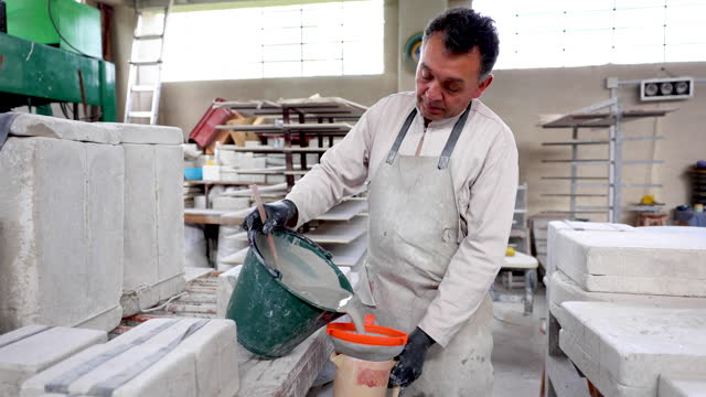 Mature potter filtering liquid clay to fill a mold at a pottery factory