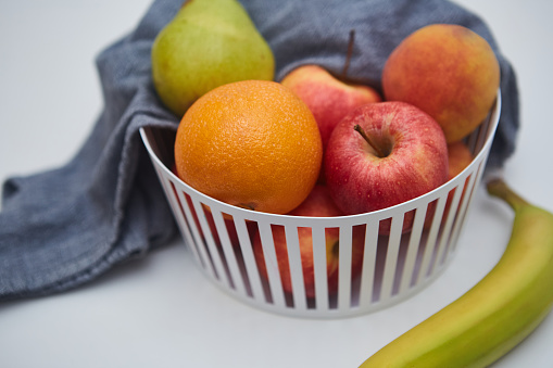 top view of pottery bowl filled with fresh organic fruits on dark background