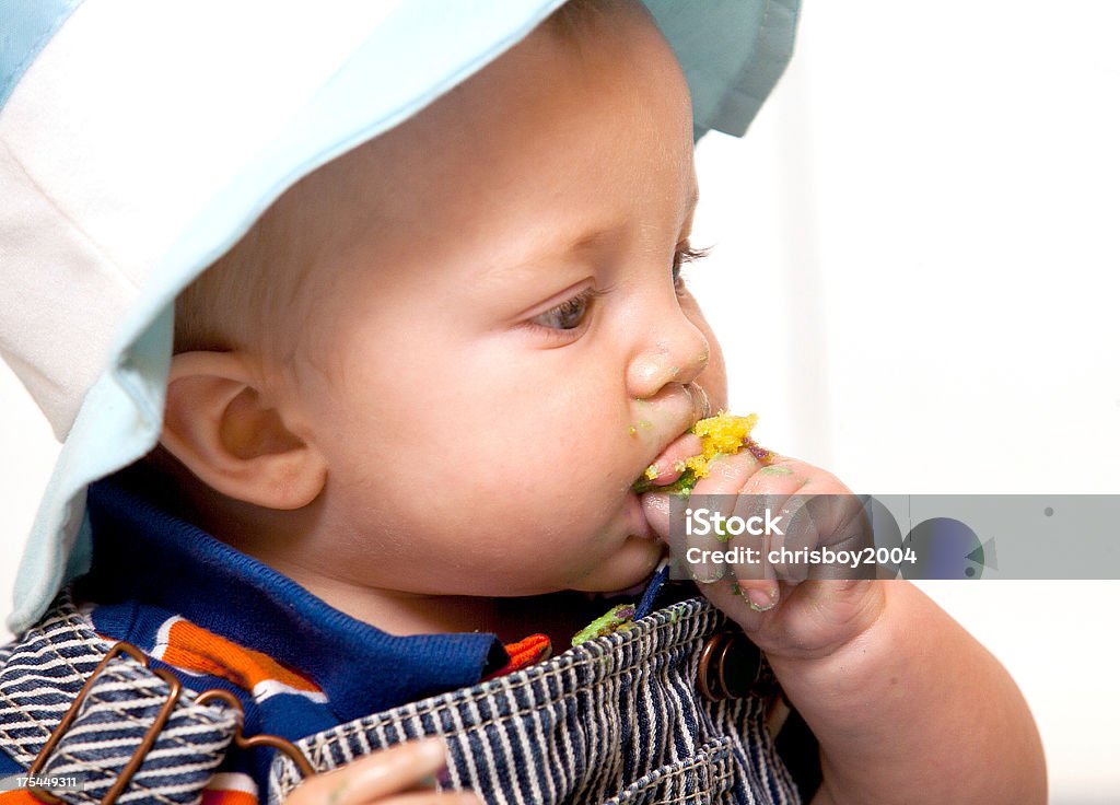 Baby eating cake "young baby eating cake, side view" Baby - Human Age Stock Photo