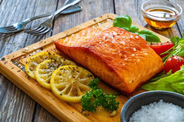 istock Seared salmon with fresh vegetables on wooden table 1754495925
