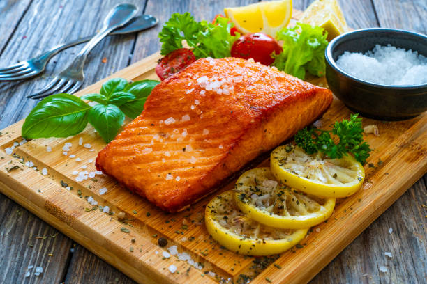 istock Seared salmon with fresh vegetables on wooden table 1754495973