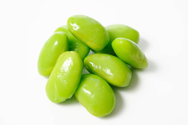 Close-up of stacked fresh boiled green soybeans isolated on white background.