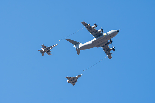 Madrid, Spain - October 12, 2023: Airbus A-400 air tanker refueling Mc Donnell Douglas F-18 Hornet and Eurofighter Typhoon during the parade of the armed forces on the day of the Spanish National Holiday