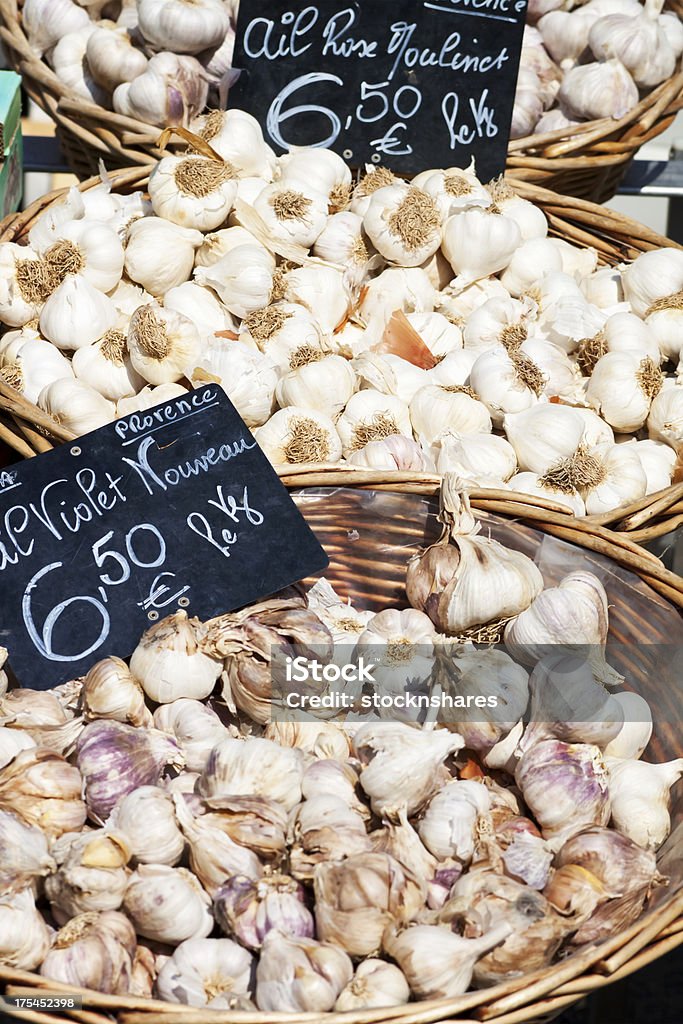 Garlic de Provence "Speciality garlic bulbs from the Provence region of France. Violet de Provence, and Rose Moulinet fresh garlic bulbs in baskets at the local market, with handwritten blackboards, with price in Euros per kilogram. Besides culinary uses, garlic has been used throughout recorded history for medicinal purposes too." Garlic Stock Photo