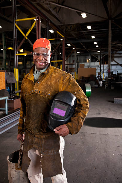 afrikanische amerikanischer arbeiter in gewebe-shop - welder manual worker african descent steel worker stock-fotos und bilder