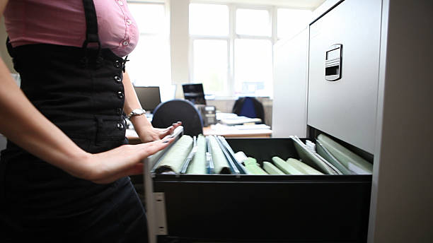 Office worker closing filing cabinet stock photo