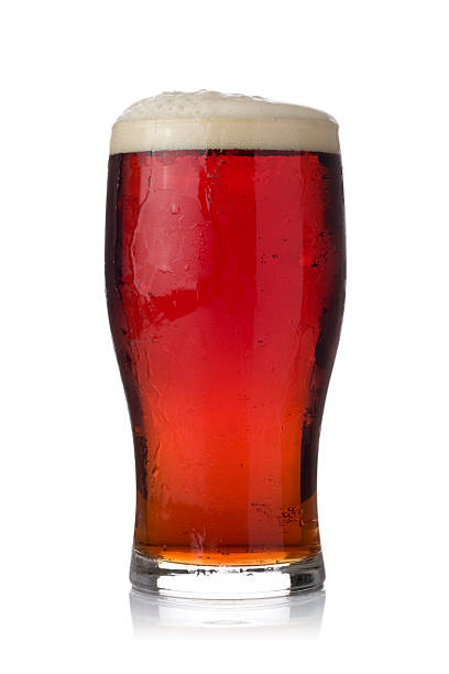 Pint of dark ale on a white background Pint of dark ale in a tulip style pint glass. Isolated on white. ale stock pictures, royalty-free photos & images