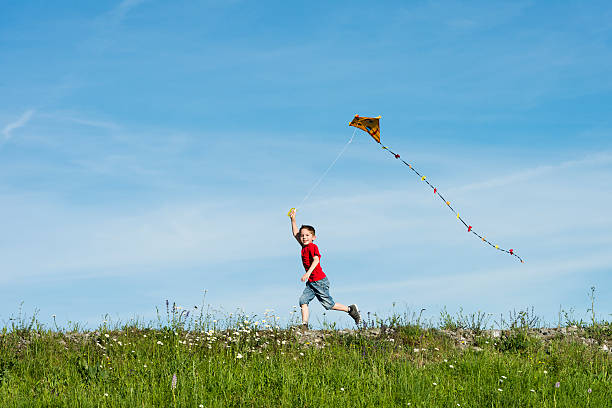 istock A happy boy running and flying his kite on a clear day 175453261