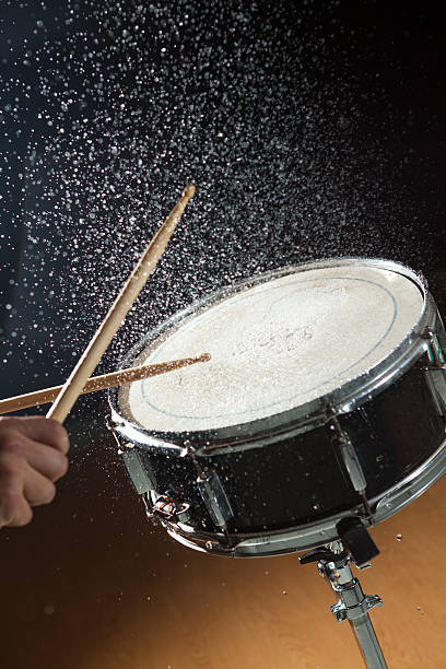 Snare Drum Water Splash Snare drum with water splashing from it's surface, after a hit by the drummer. High-speed strobes used to freeze the motion snare drum stock pictures, royalty-free photos & images