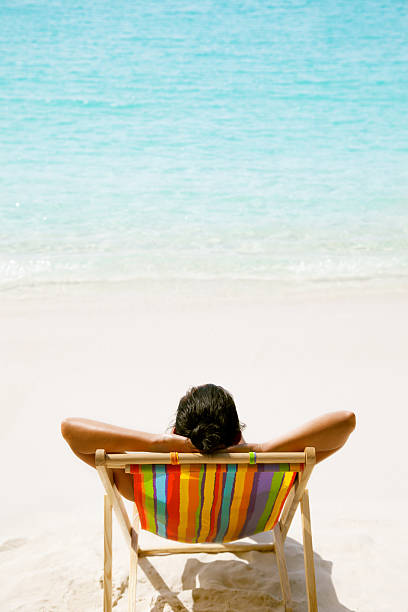 istock woman with arms behind her head at a tropical beach 175453427
