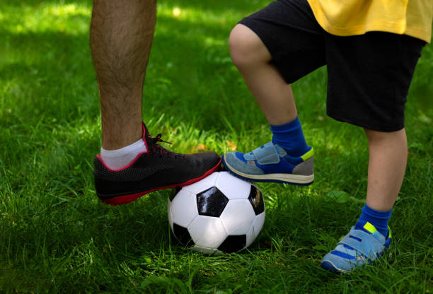 istock father son foot on football ball 1754537183