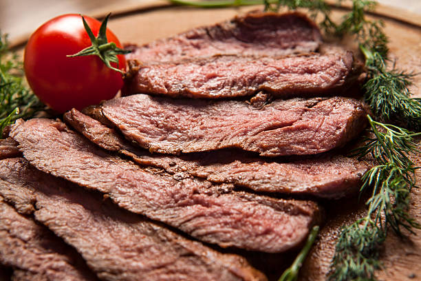 istock Sliced grilled meat displayed on wooden cutting board 175453782