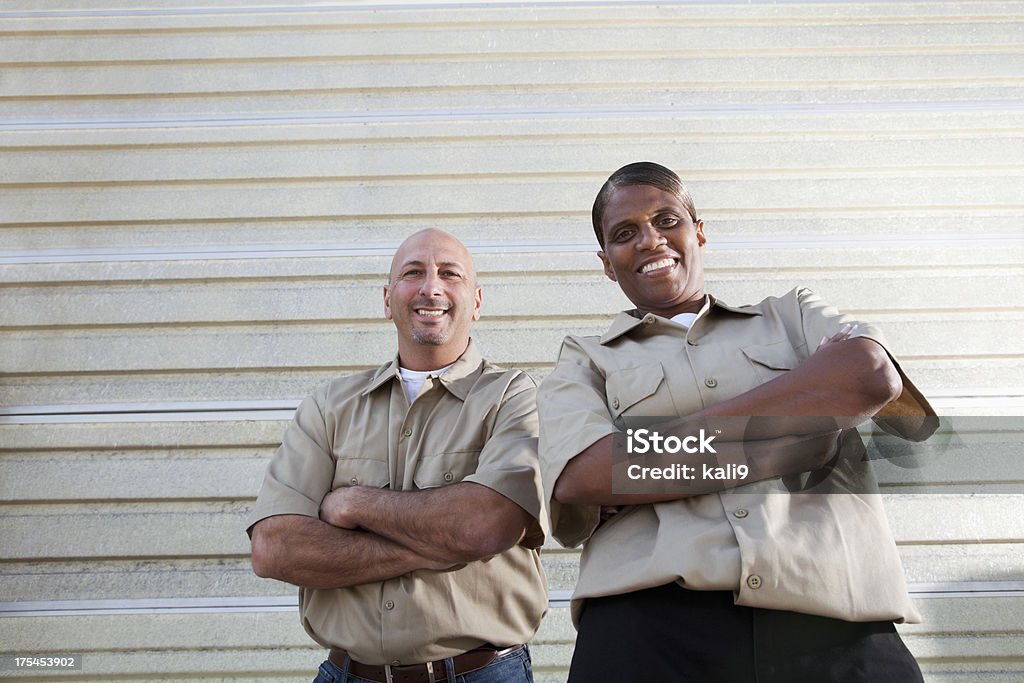 Workers standing in front of warehouse door Multi-ethnic workers standing in front of warehouse door. 30-39 Years Stock Photo