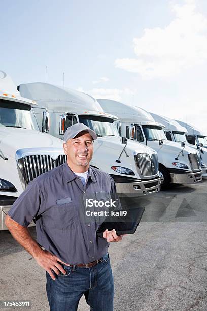 Truck Driver In Front Of Big Rigs With Digital Tablet Stock Photo - Download Image Now