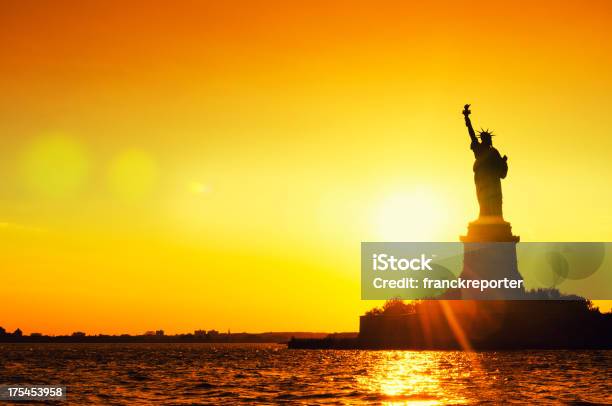 Estátua Da Liberdade Silhouetted Ao Anoitecercidade De Nova Iorque - Fotografias de stock e mais imagens de Dourado - Cores