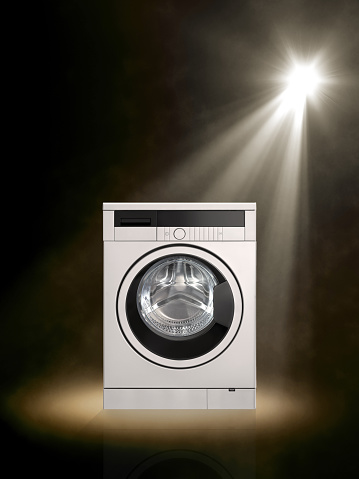 Spot lit washer and dryer combo machine on colored background