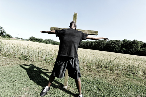 African American male in front of the cross.