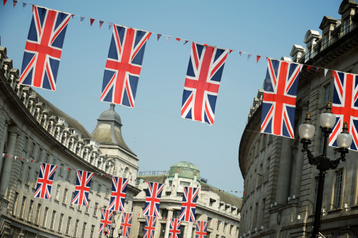 Union Jack British flags hang across curving street in Central London