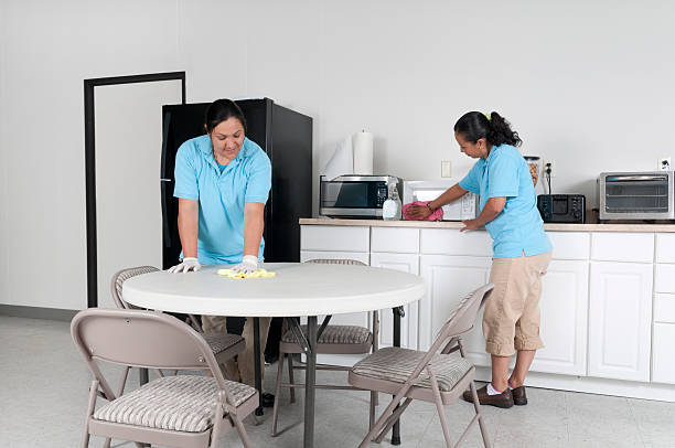 Two Women Cleaning a Corporate Break Room stock photo