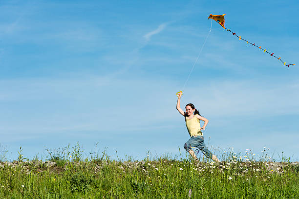 istock happy girl flying her kite 175454392