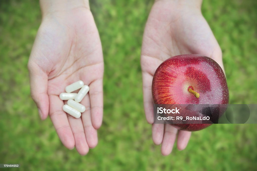 A sua opção de medicamentos pílulas ou maçã - Foto de stock de Suplemento nutricional royalty-free