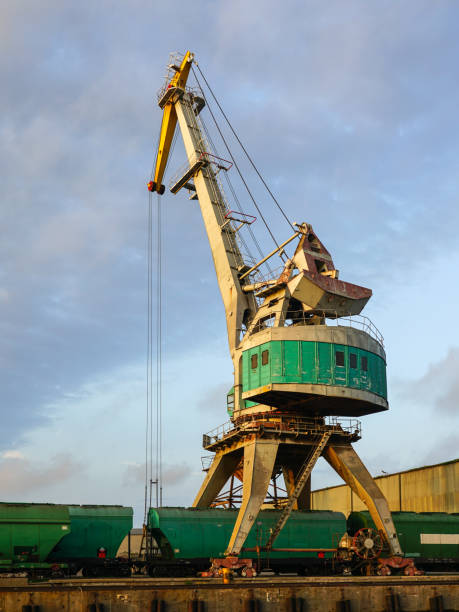 istock Harbor crane with grain wagons between crane legs, seaport industry scene, grain export 1754550239