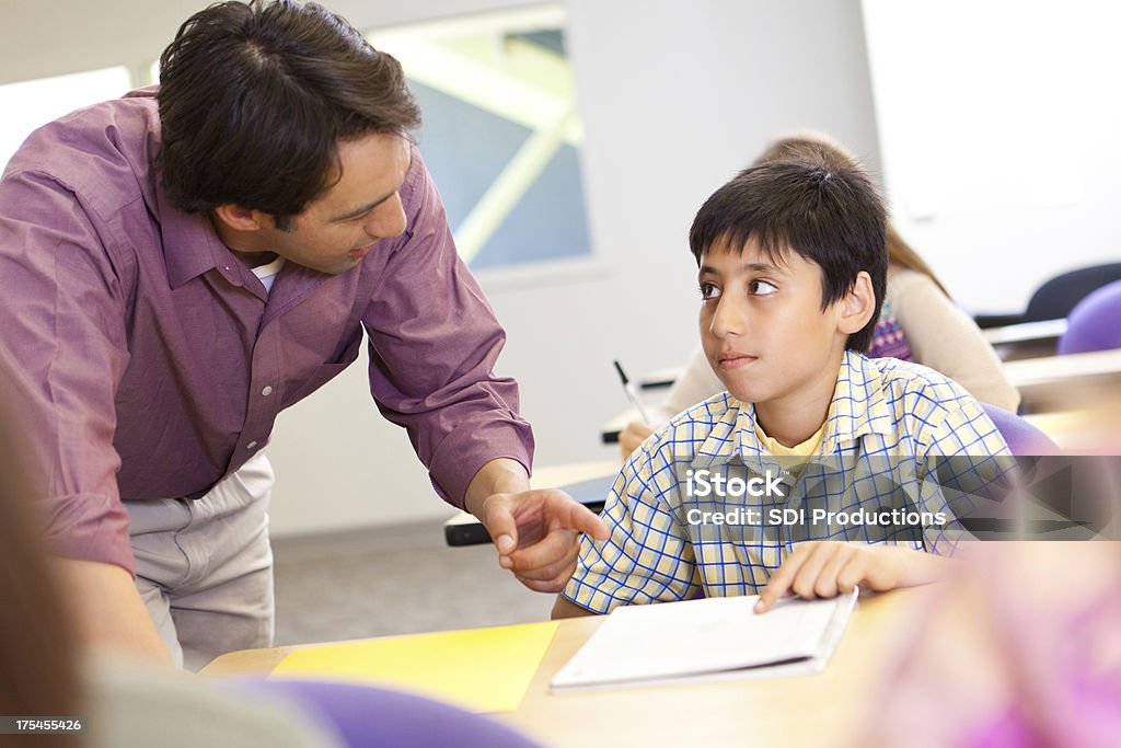 Instructing Class Teacher Instructing Student With Work In Class Stock Photo - Download ...