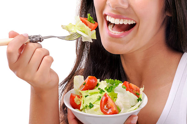 istock Young smiling woman eating salad 175455497