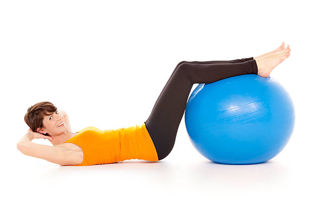 istock pilates series - woman training with gym ball 175455525