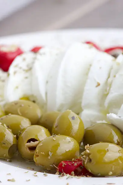 "Italian starter with buffalo mozzarella, olives and stuffed peppers"