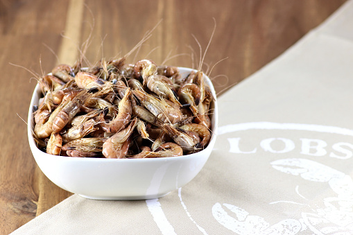 unpeeled brown shrimps in a ceramic bowl