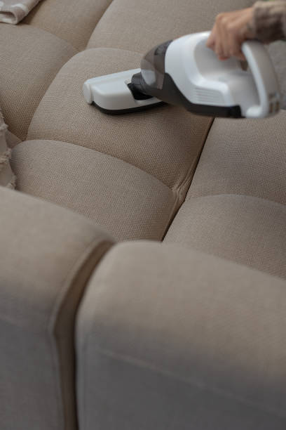 istock Wireless handheld vacuumer cleaning beige neutral color couch. 1754568606