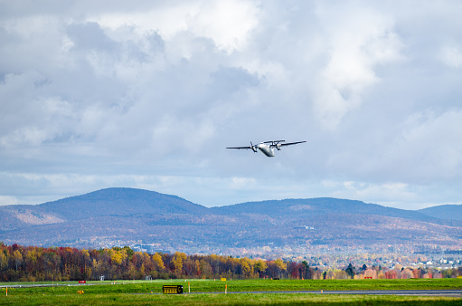 Small propeller airplane taking off at the Quebec city airport during autumn day